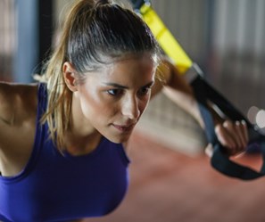 A focussed-looking woman exercising with resistance bands