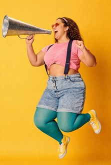 A woman jumping in the air, shouting from a megaphone