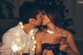 A young couple kissing at a celebration