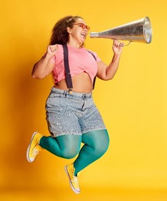 A lady leaping with a megaphone, shouting out loud