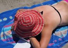 Lady lying on beach towel in big hat